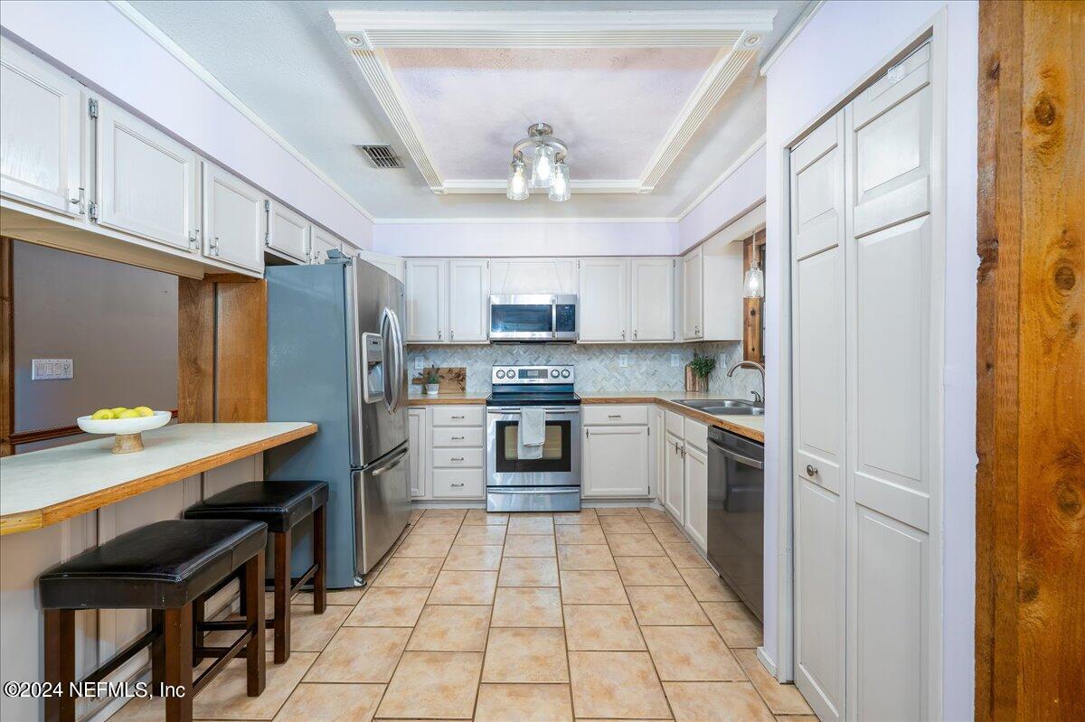 4847 Reed Avenue Jacksonville, FL 32257 - Photo 9 of 36 a kitchen with stainless steel appliances granite countertop a refrigerator a sink dishwasher a stove with white cabinets and countertops