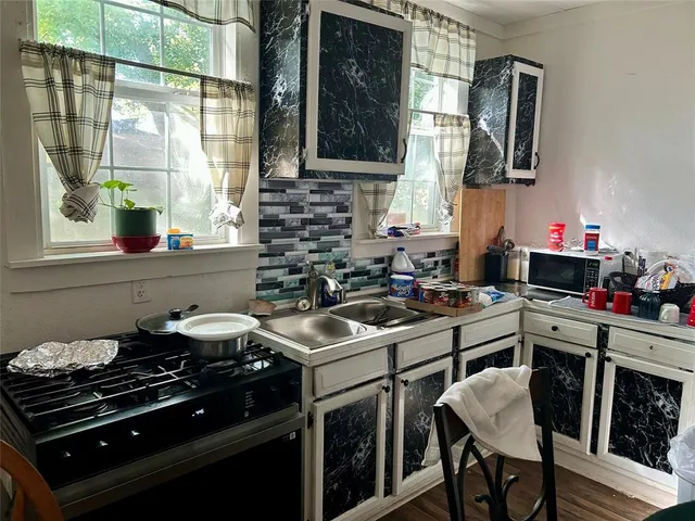 a kitchen with a stove a sink and a microwave
