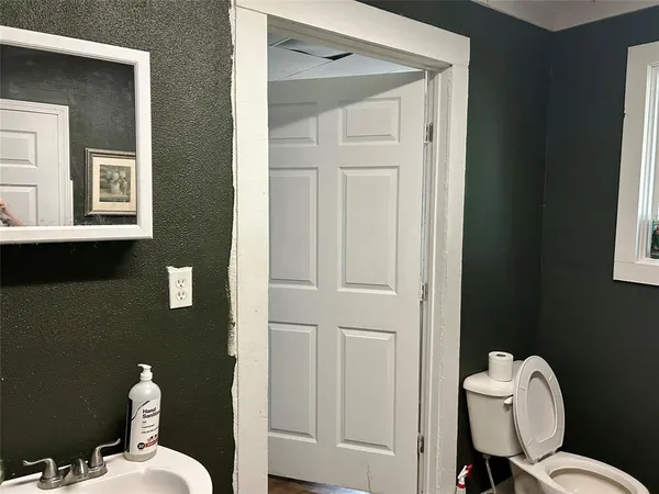 a bathroom with a toilet a sink and mirror