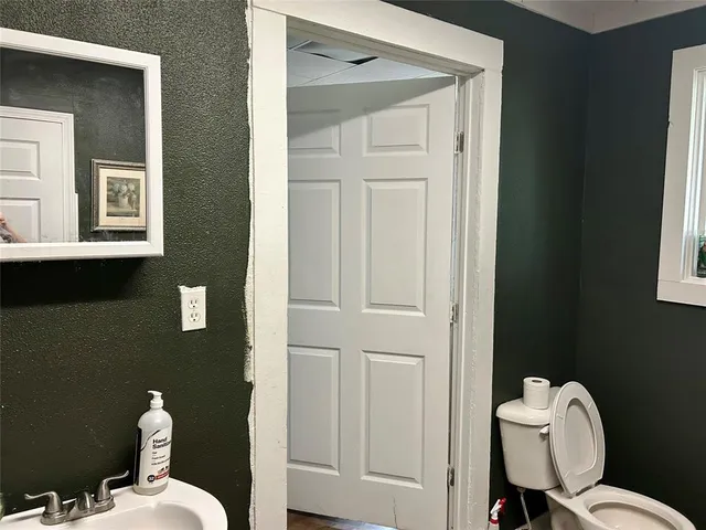 a bathroom with a toilet a sink and mirror