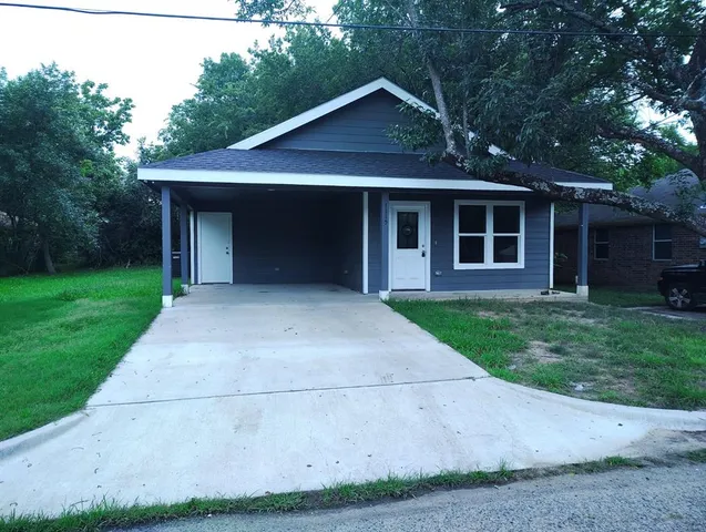 a front view of a house with a garden and yard