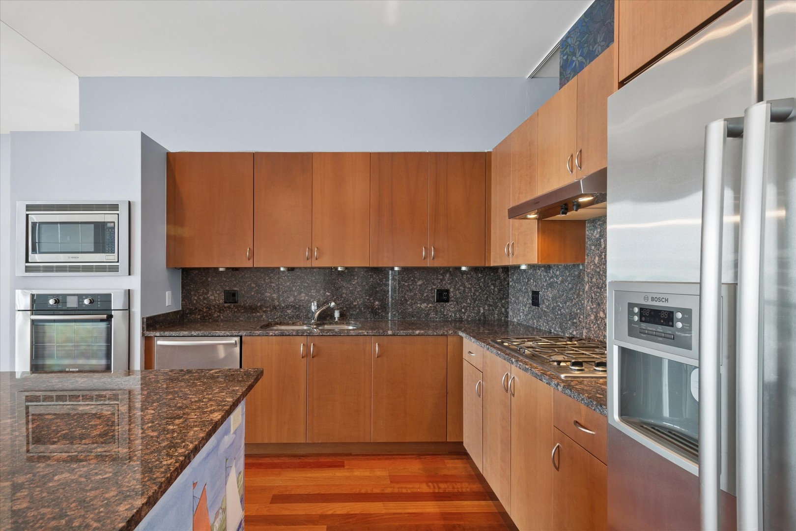 65 East Monroe Street, Unit 4521 Chicago, IL 60603 - Photo 5 of 25 a kitchen with stainless steel appliances granite countertop a sink and wooden cabinets