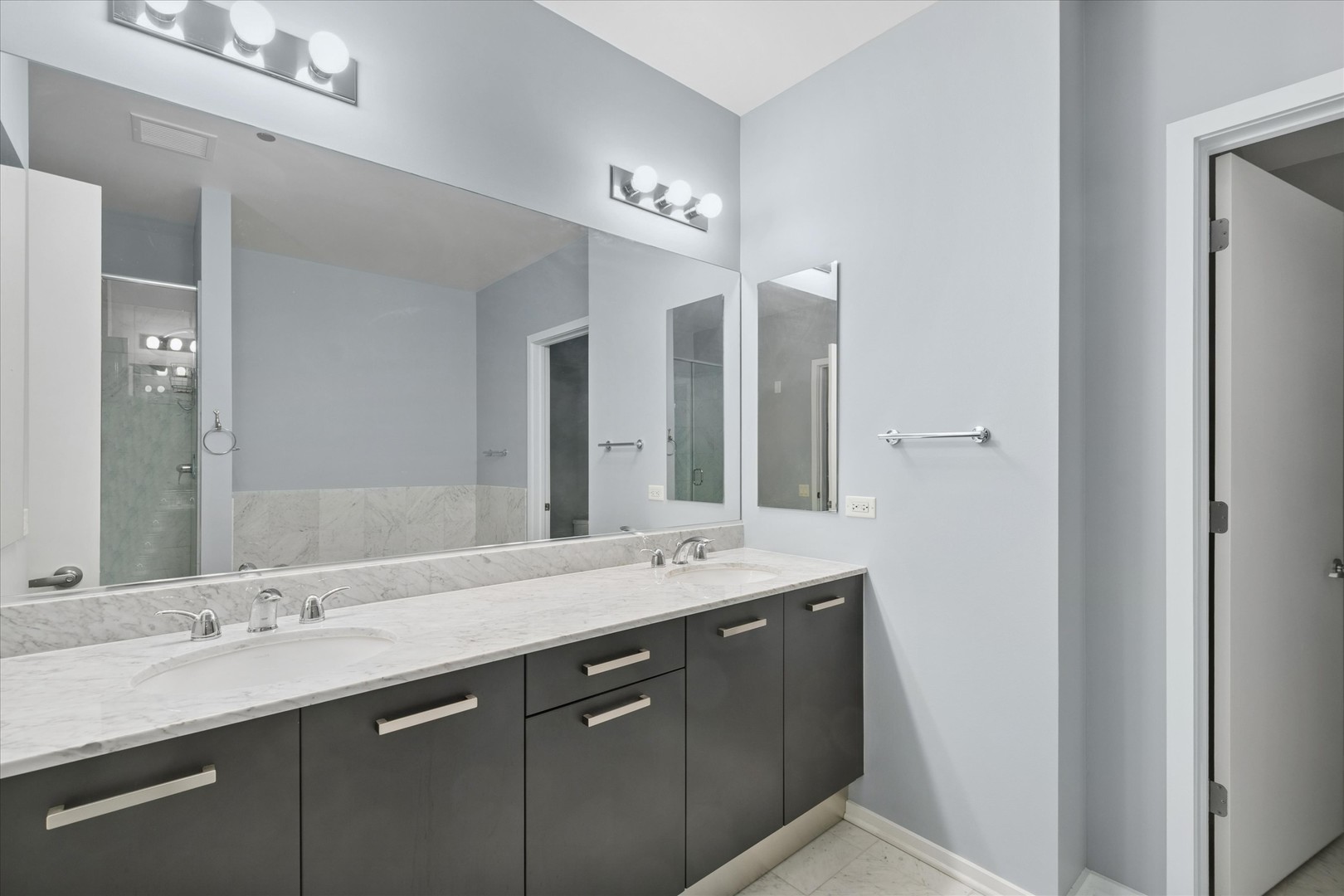 65 East Monroe Street, Unit 4521 Chicago, IL 60603 - Photo 7 of 25 a bathroom with a double vanity sink and a mirror