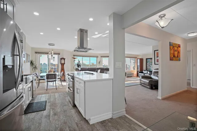 a kitchen with stainless steel appliances kitchen island granite countertop a refrigerator and a sink