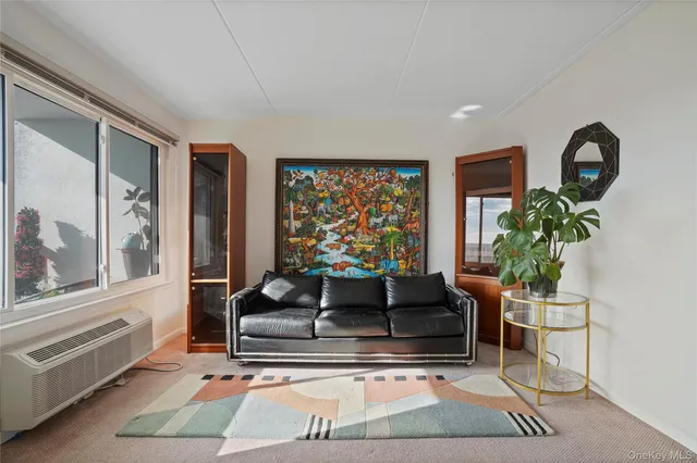 a living room with furniture a flat screen tv and kitchen view