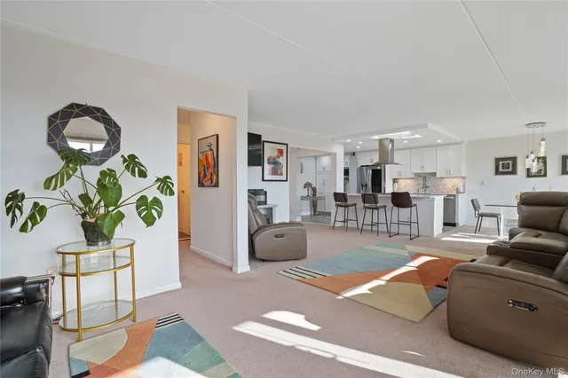 a living room with furniture a window and a potted plant