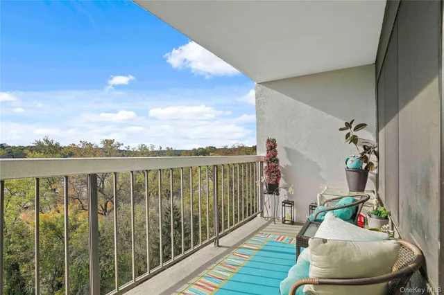 a view of a balcony with chair and white door with wooden floor