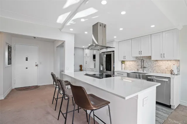a kitchen with a dining table chairs stainless steel appliances and cabinets