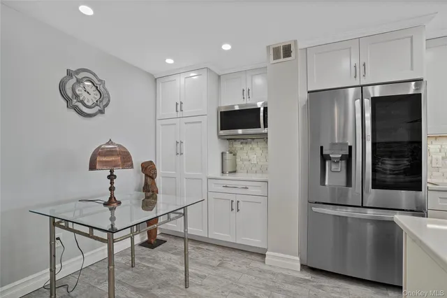a kitchen with stainless steel appliances granite countertop a sink and a refrigerator