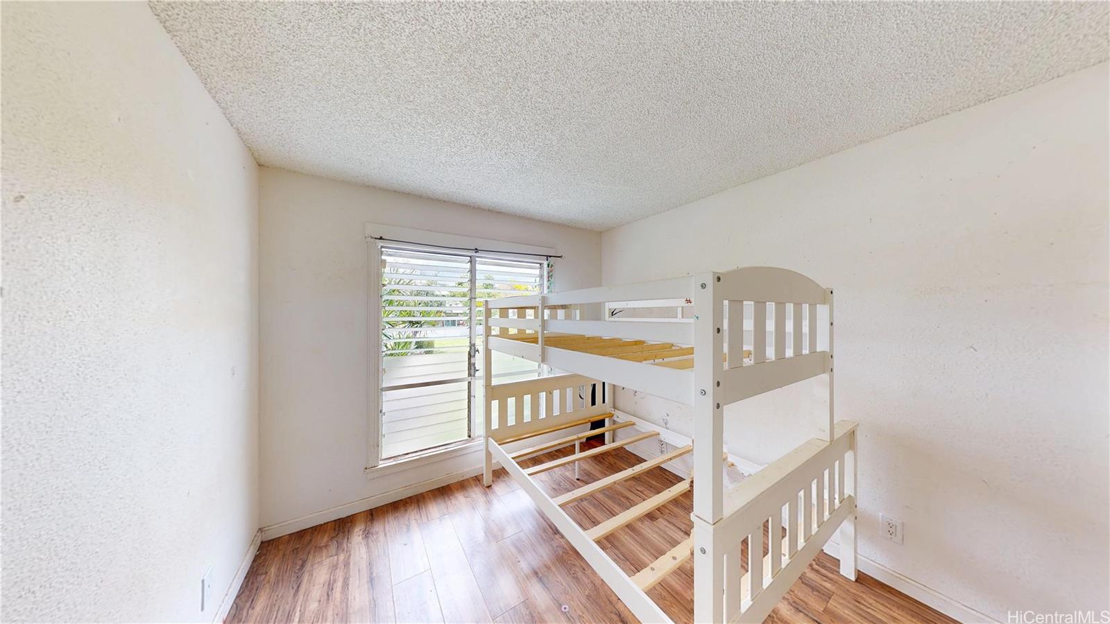 92-1244 Kikaha Street, Unit 14 Kapolei, HI 96707 - Photo 14 of 25 a view of an empty room with wooden floor and windows