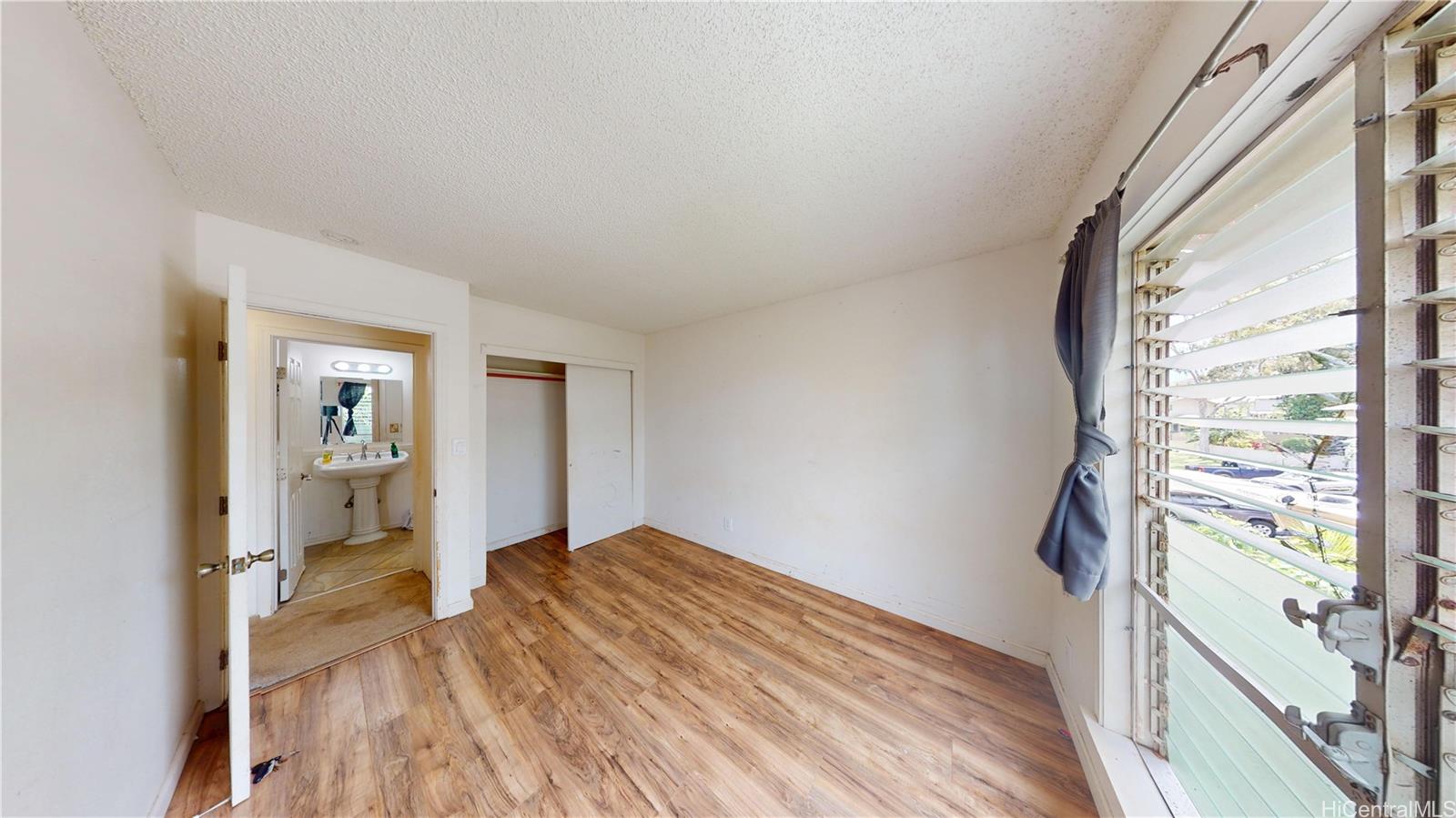 92-1244 Kikaha Street, Unit 14 Kapolei, HI 96707 - Photo 16 of 25 a view of an empty room with wooden floor and a window
