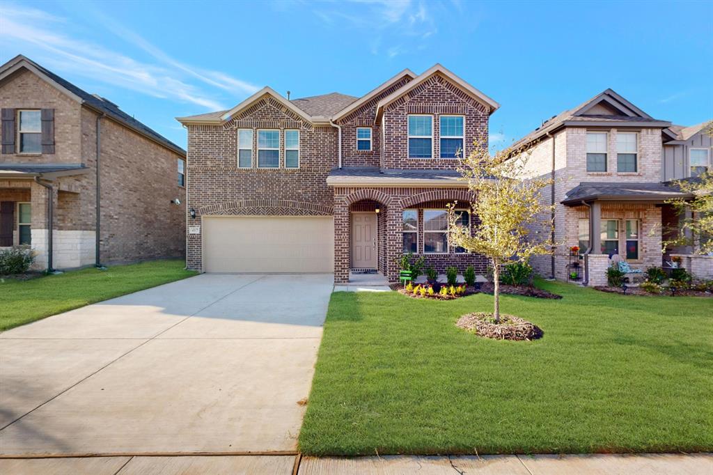 a front view of a house with a yard and garage