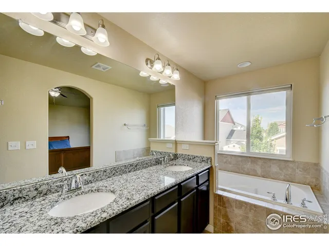 a bathroom with a granite countertop sink a large mirror and a bathtub