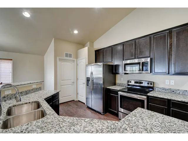 a kitchen with kitchen island granite countertop a sink stove and refrigerator