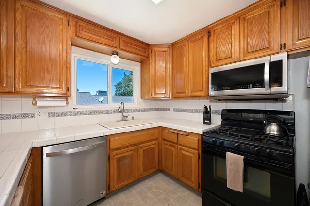 a kitchen with stainless steel appliances a stove sink microwave and cabinets
