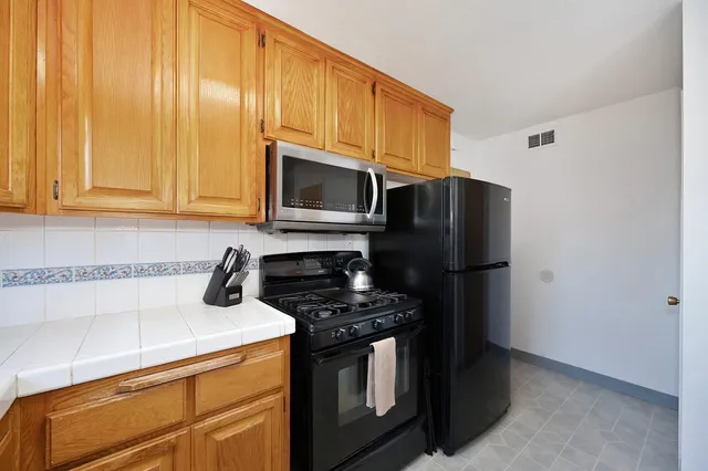 a kitchen with stainless steel appliances a stove microwave and refrigerator