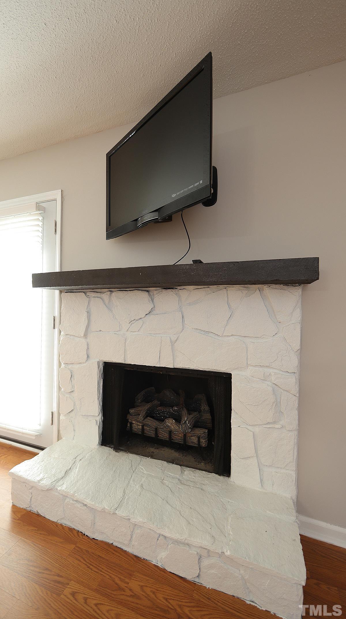 5758 Pool Side Drive Raleigh, NC 27612 - Photo 11 of 24 a living room with a fireplace and a flat screen tv