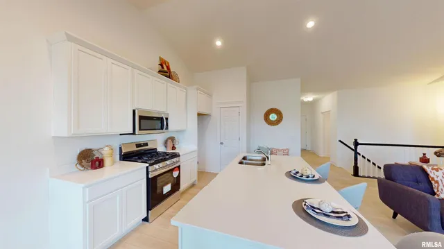 a kitchen with a refrigerator a stove a sink and a dining table with wooden floor