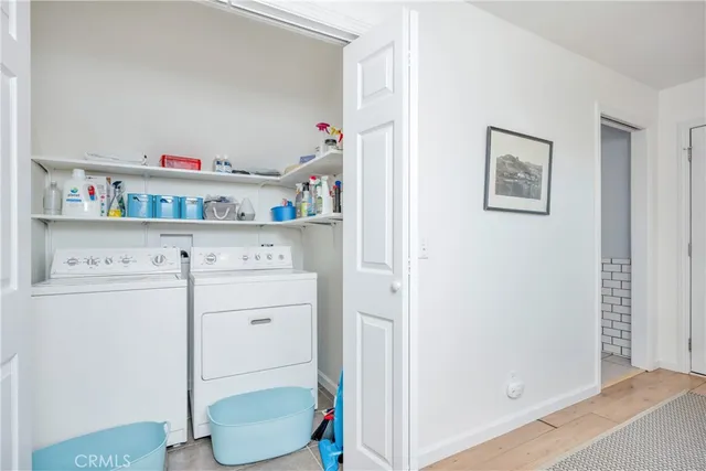 a hallway with painting on the wall and a refrigerator
