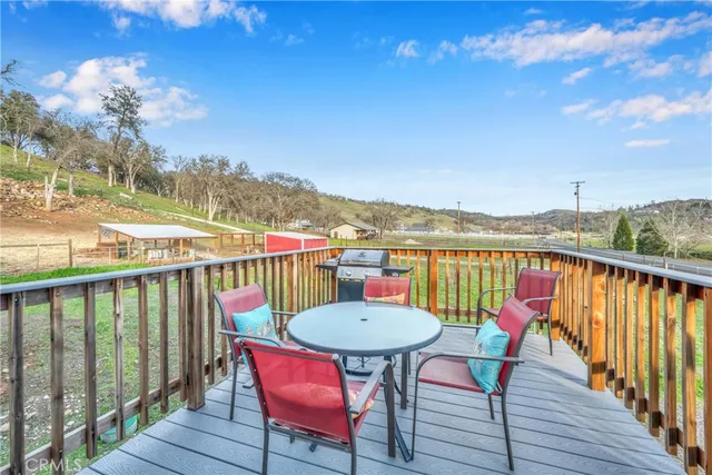 a balcony with wooden floor table and chairs
