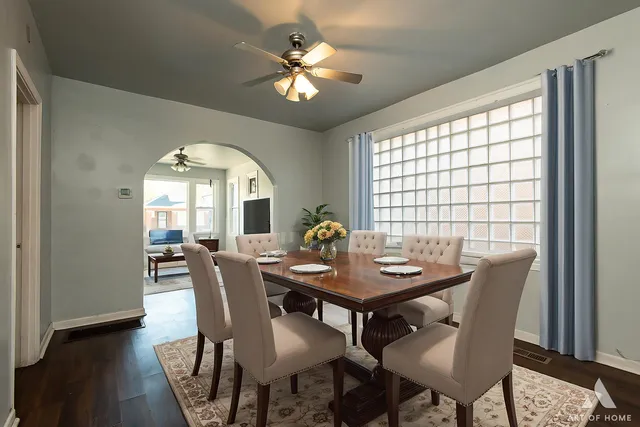 a dining room with furniture a chandelier and wooden floor