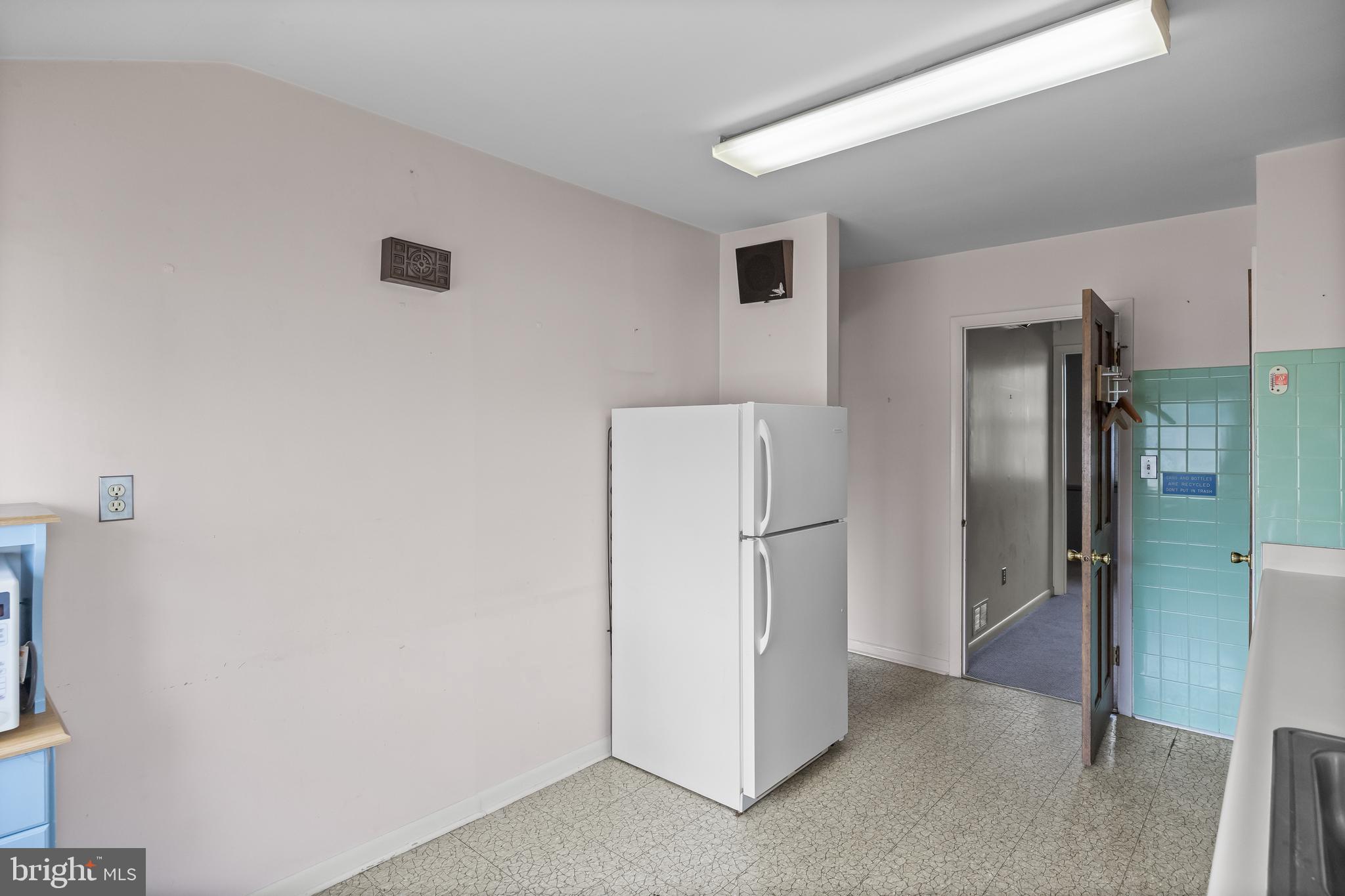 64 Warwick Road Stratford, NJ 08084 - Photo 18 of 28 a view of a kitchen with a refrigerator and cabinets