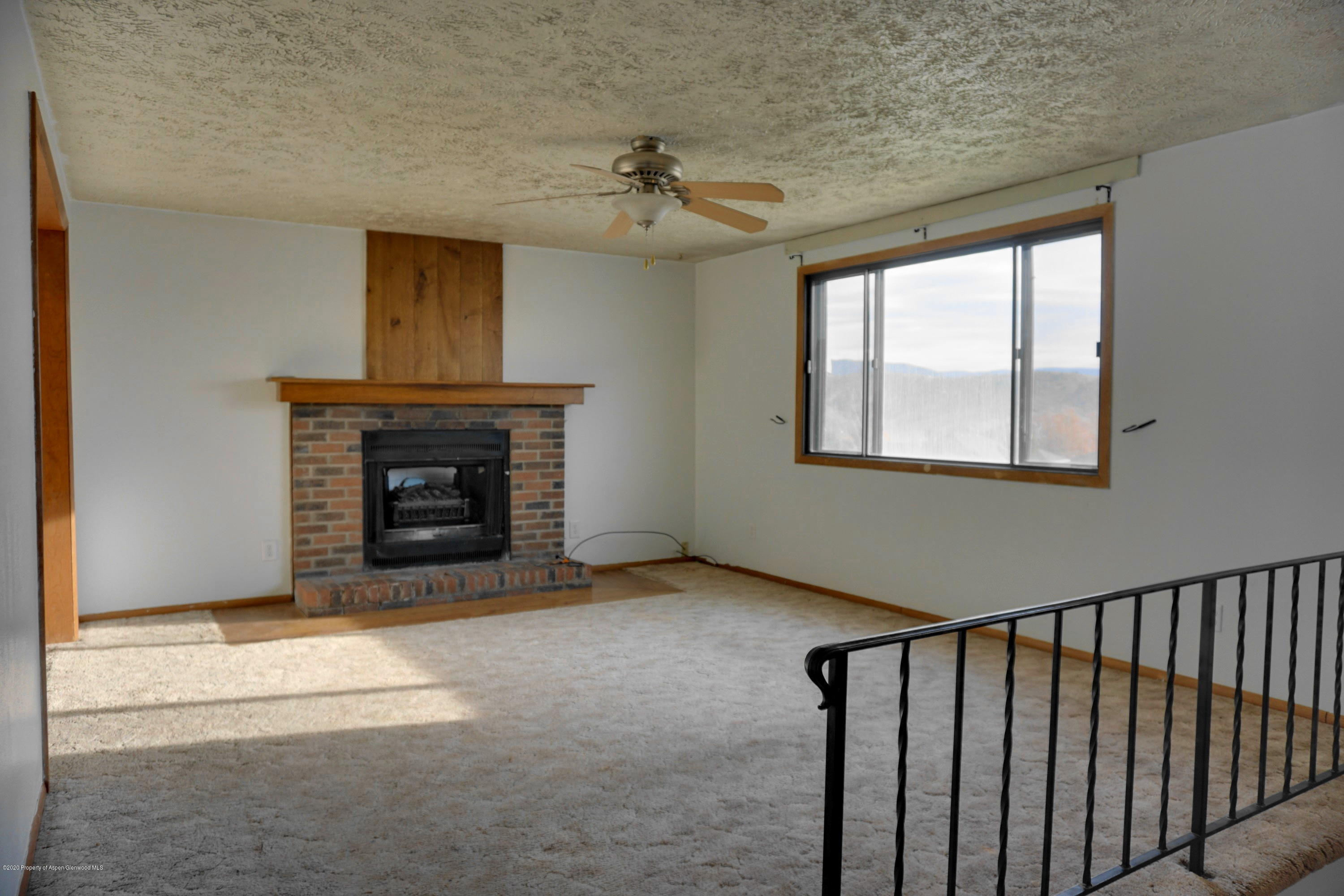 1409 Silver Sage Road Meeker, CO 81641 - Photo 2 of 26 a view of an empty room with a fireplace and a window