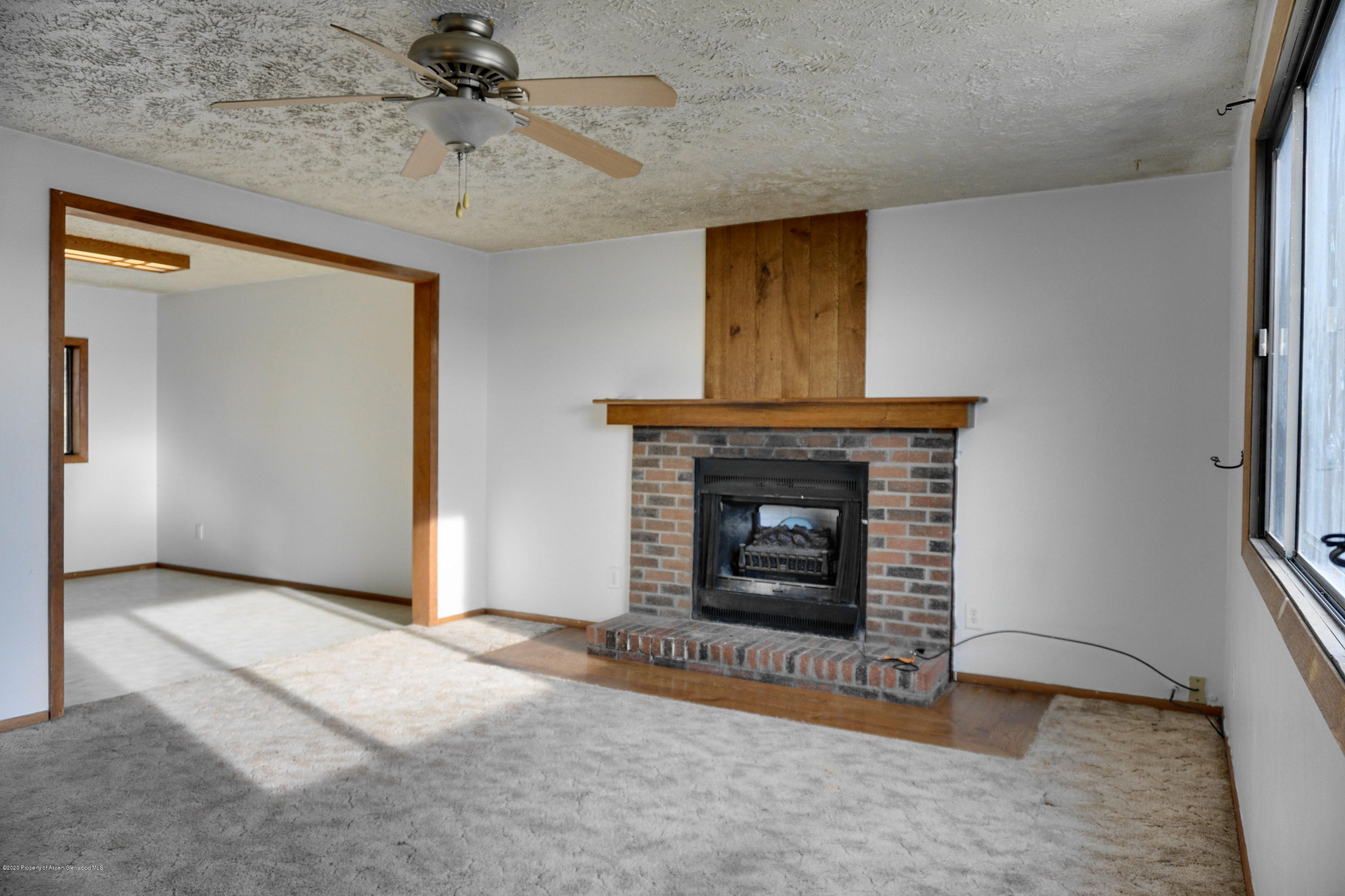 1409 Silver Sage Road Meeker, CO 81641 - Photo 3 of 26 an empty room with windows and fireplace