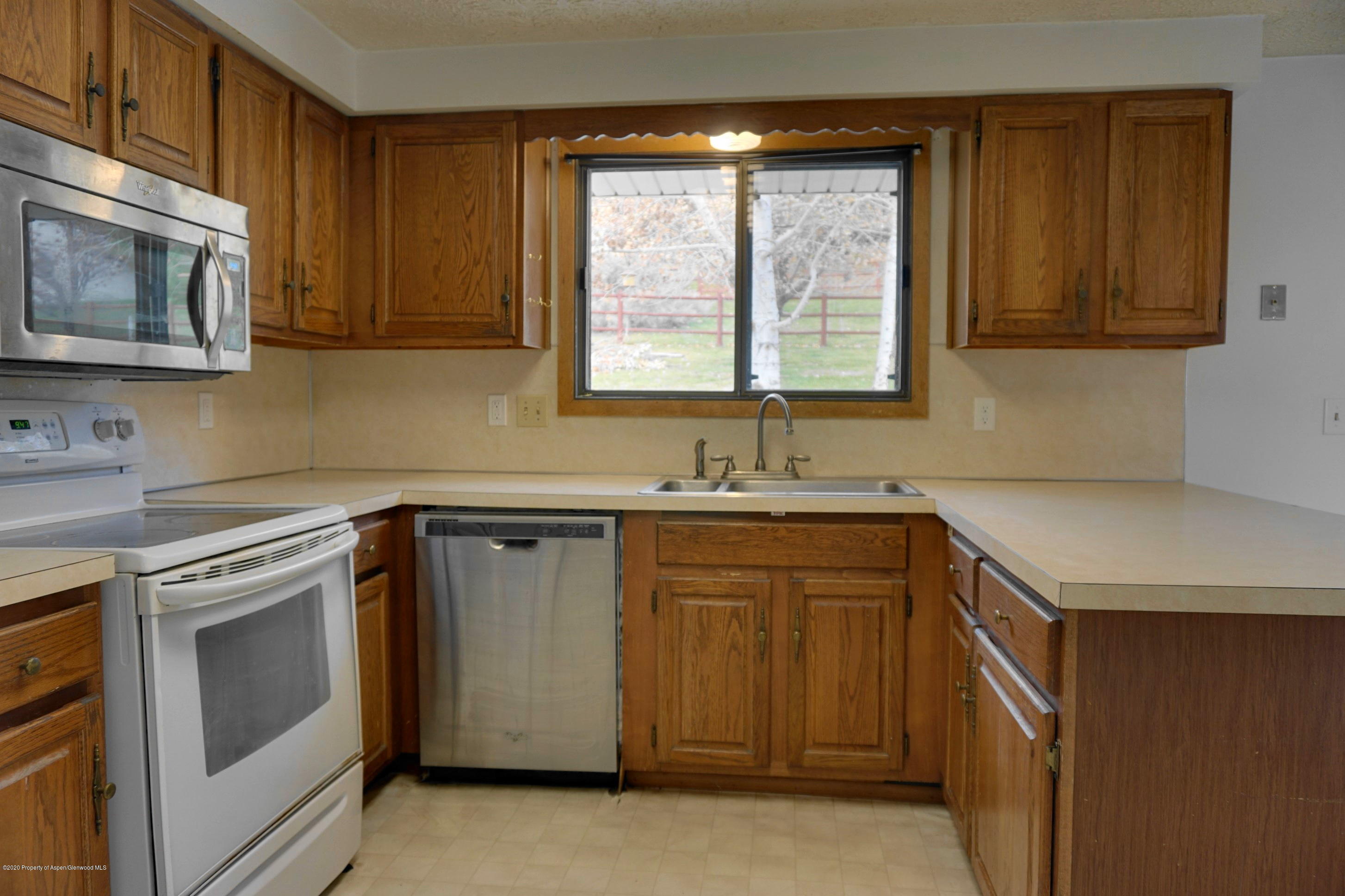 1409 Silver Sage Road Meeker, CO 81641 - Photo 8 of 26 a kitchen with granite countertop a sink a stove and microwave