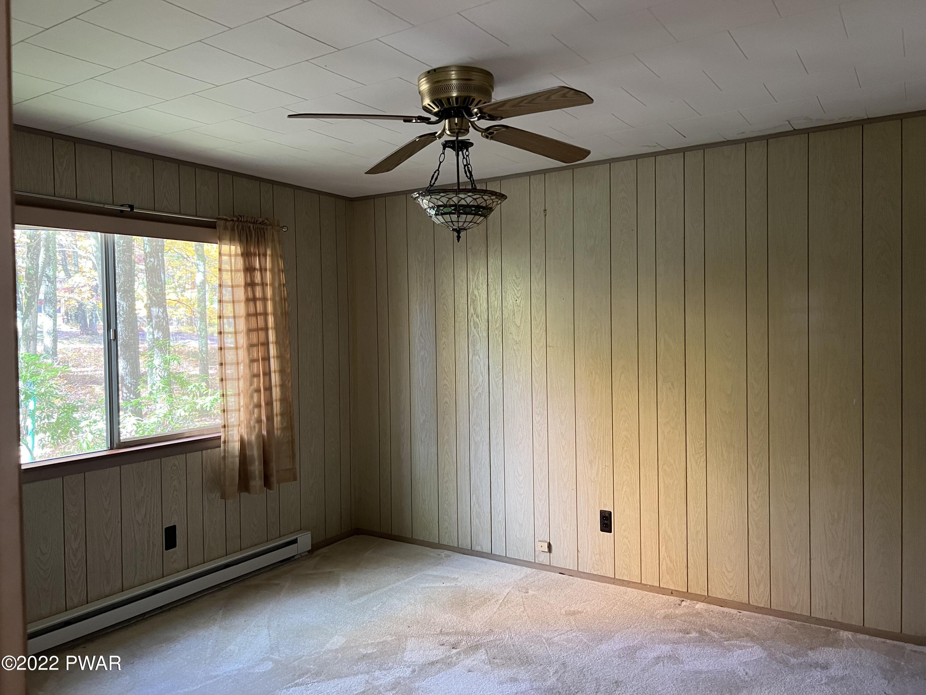 135 Rodeo Drive Hawley, PA 18428 - Photo 13 of 23 an empty room with windows and a ceiling fan