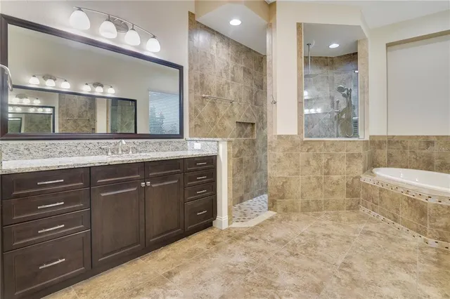 a spacious bathroom with a granite countertop sink a mirror and a