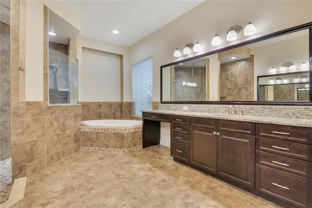 a bathroom with a sink bathtub and a large mirror
