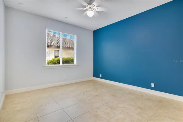 an empty room with a window and a fan