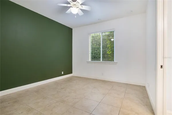 an empty room with a window and a chandelier fan