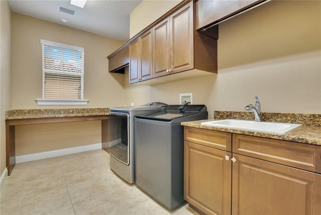 6510 Eagle Ridge Way Lakeland, FL 33813 - Photo 29 of 50 a utility room with granite countertop cabinets washer and dryer