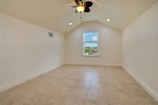 an empty room with a window and a ceiling fan