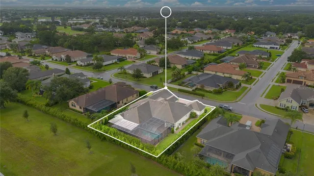 an aerial view of a house with a garden and lake view