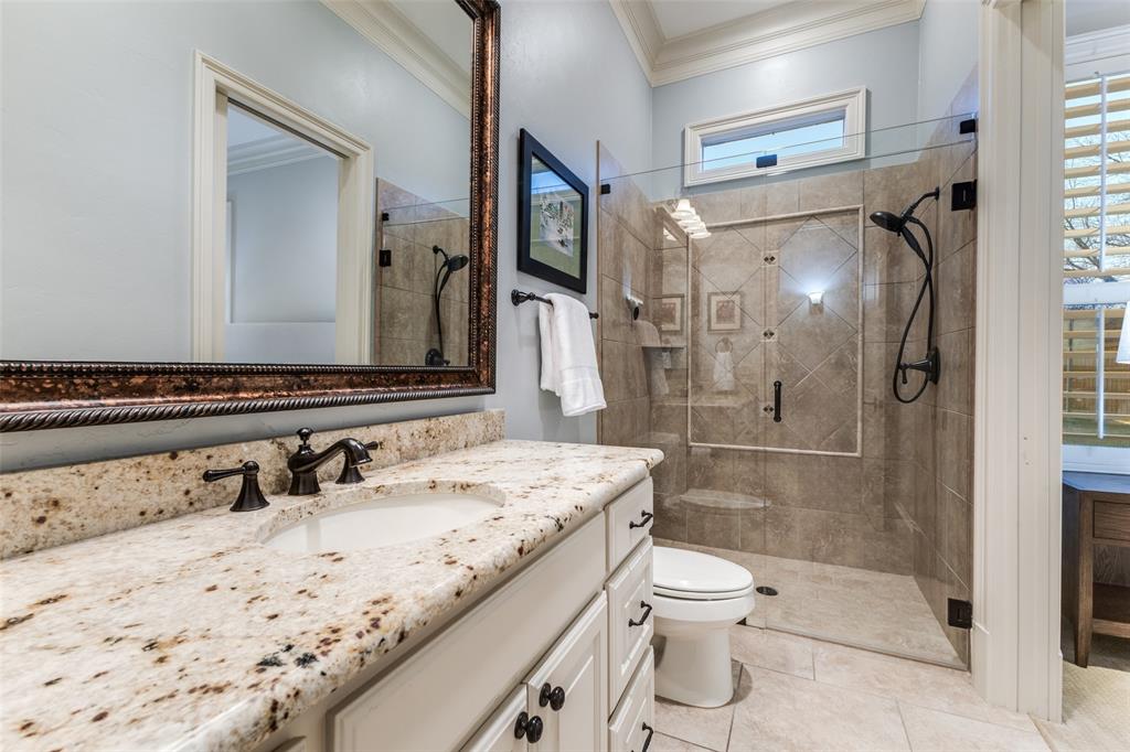 6031 Azalea Lane Dallas, TX 75230 - Photo 19 of 38 a bathroom with a granite countertop sink toilet mirror and shower