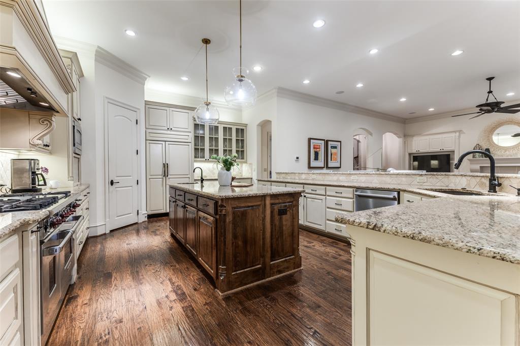 6031 Azalea Lane Dallas, TX 75230 - Photo 9 of 38 a kitchen with stainless steel appliances granite countertop a lot of counter space and wooden floors