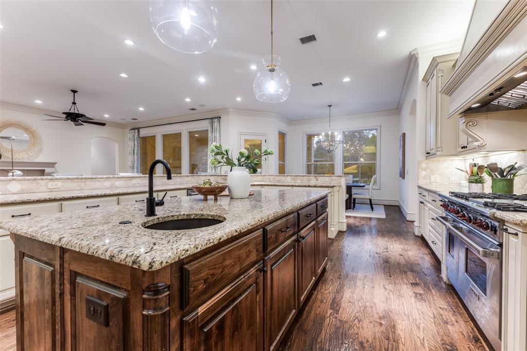 6031 Azalea Lane Dallas, TX 75230 - Photo 10 of 38 a kitchen with stainless steel appliances granite countertop a sink a stove and a wooden floors