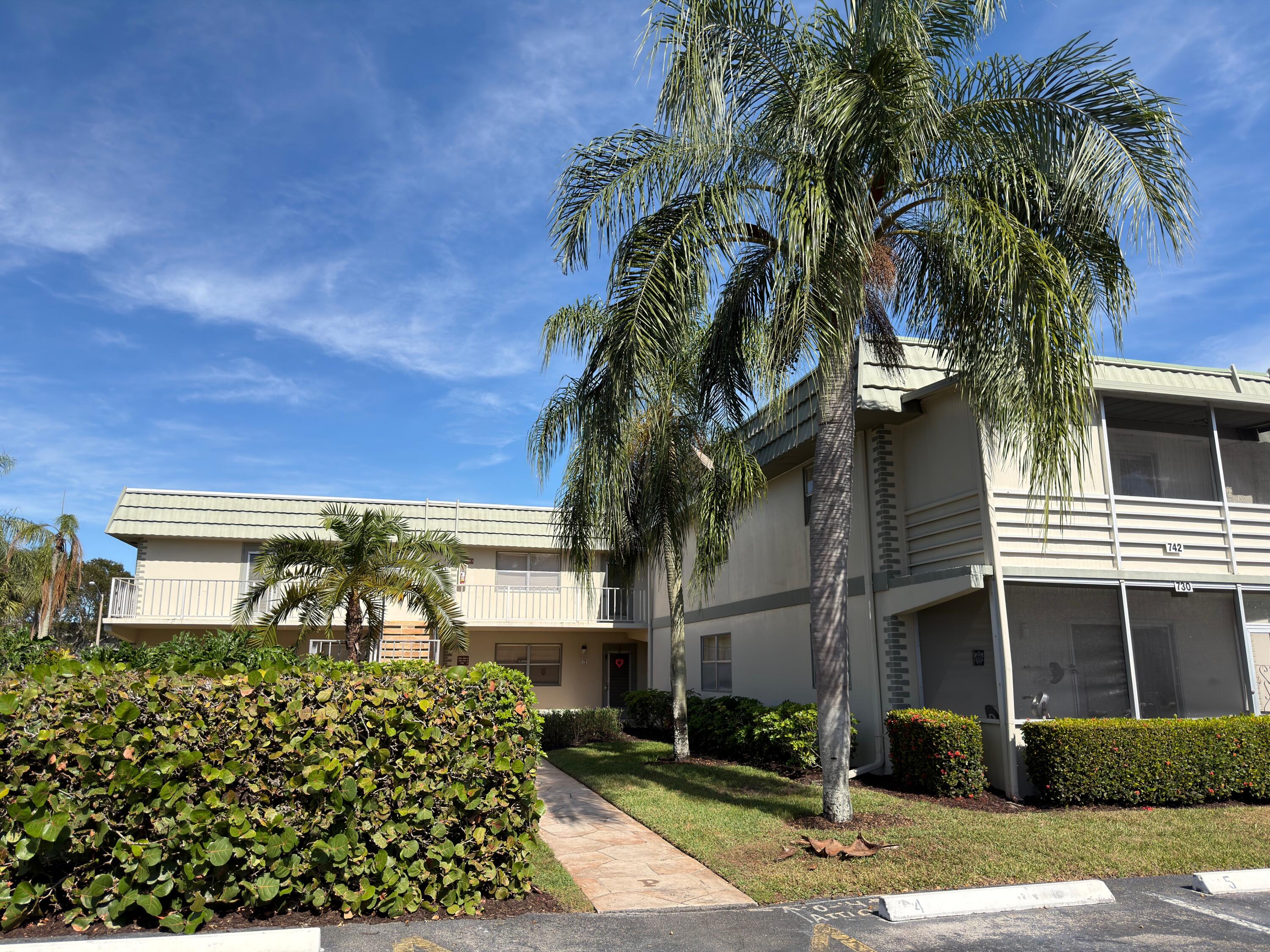 741 Monaco P, Unit 741 Delray Beach, FL 33446 - Photo 2 of 18 a front view of a house with a yard