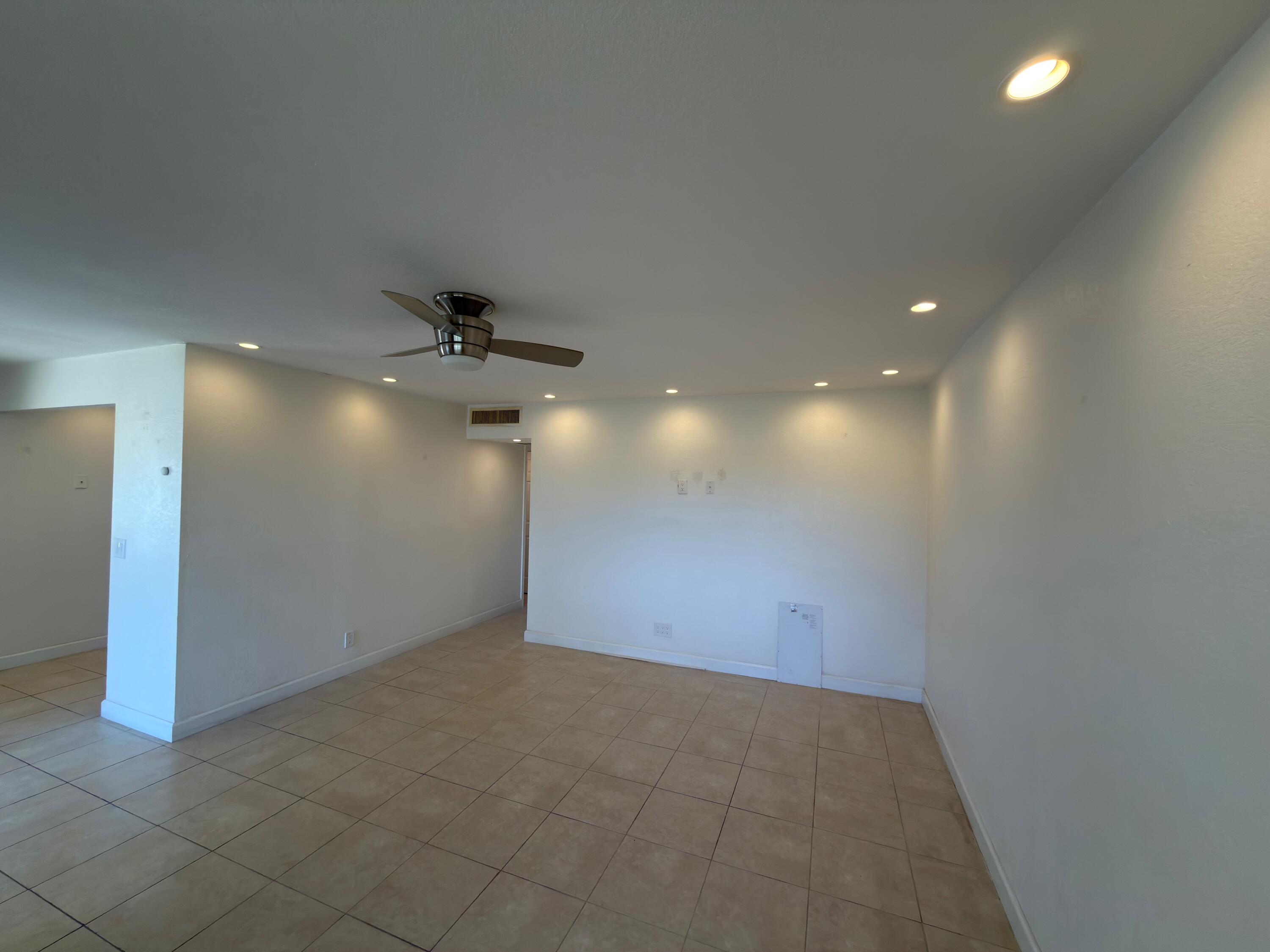 741 Monaco P, Unit 741 Delray Beach, FL 33446 - Photo 6 of 18 an empty room with a ceiling fan and a window