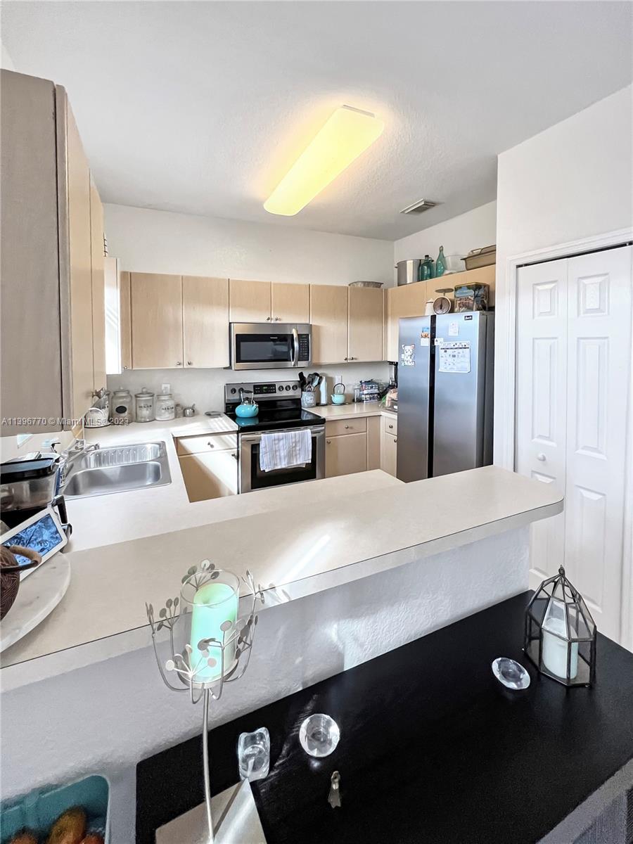 12524 Southwest 126th Avenue Miami, FL 33186 - Photo 12 of 23 a large kitchen with a table chairs and refrigerator