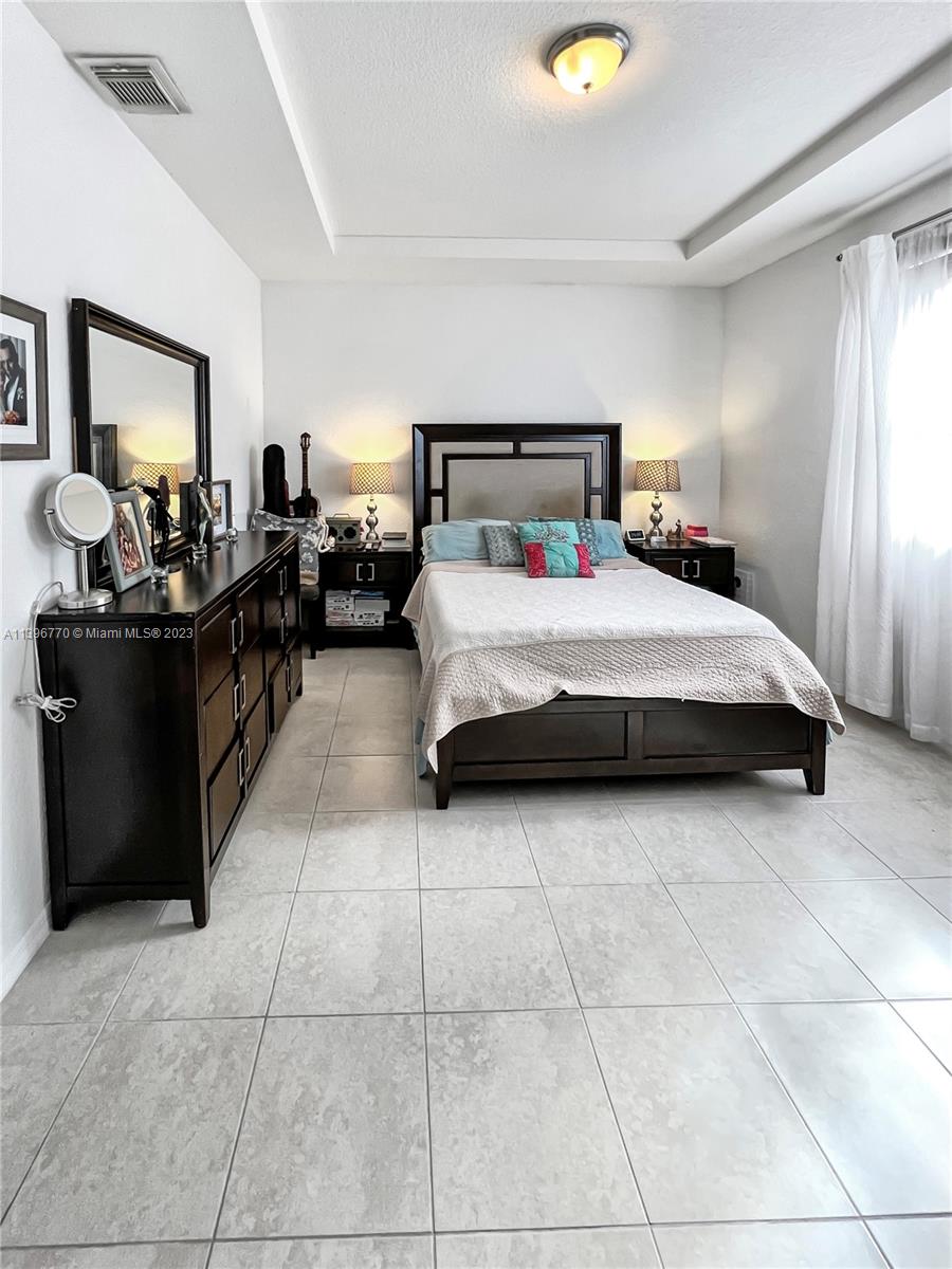 12524 Southwest 126th Avenue Miami, FL 33186 - Photo 14 of 23 a bedroom with a bed and a chandelier