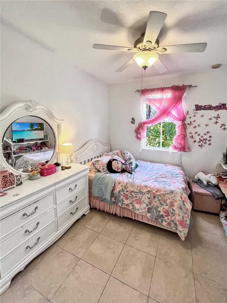12524 Southwest 126th Avenue Miami, FL 33186 - Photo 21 of 23 a bedroom with a bed and a dresser in it