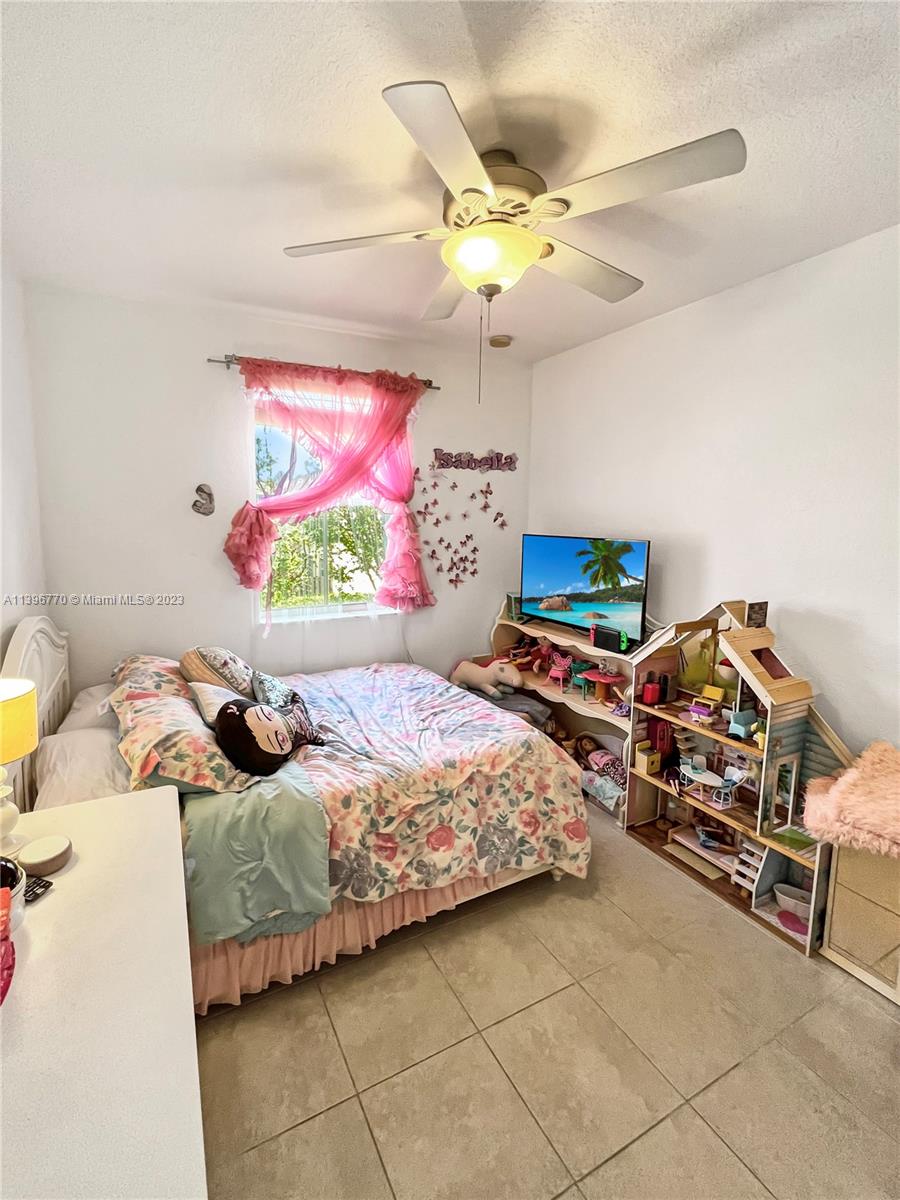 12524 Southwest 126th Avenue Miami, FL 33186 - Photo 22 of 23 a bedroom with a bed and a chandelier