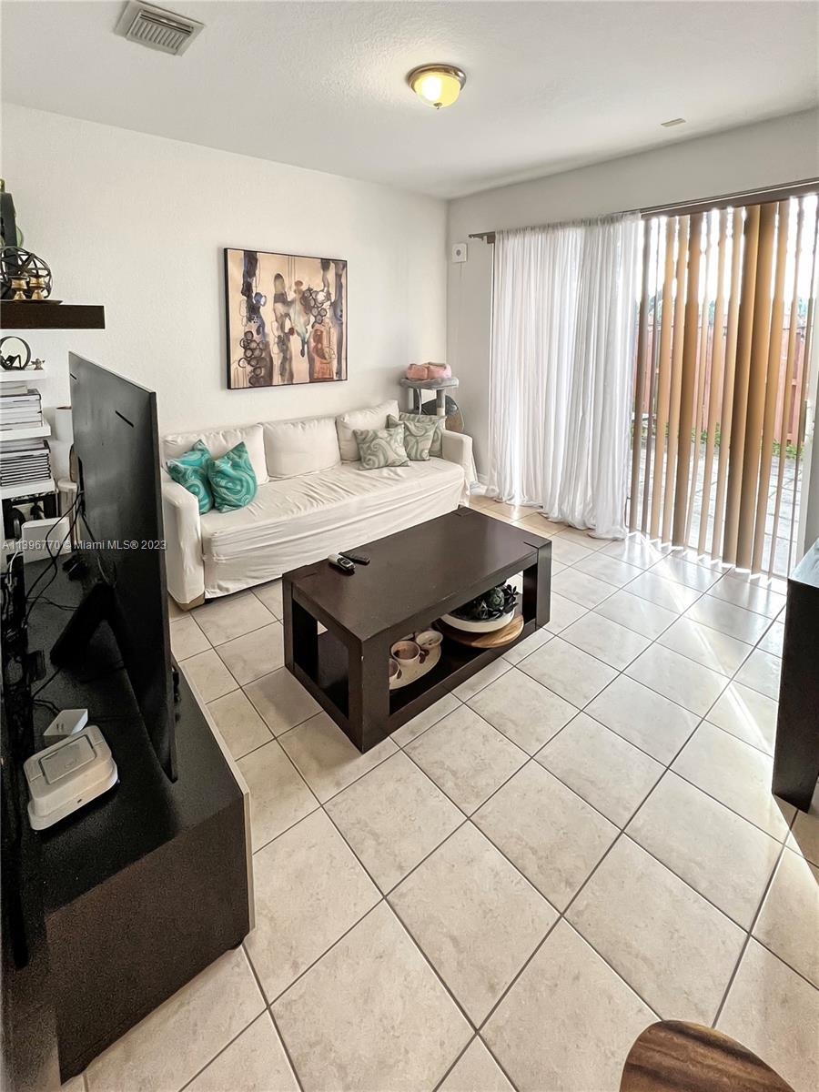 12524 Southwest 126th Avenue Miami, FL 33186 - Photo 9 of 23 a living room with furniture a window and a flat screen tv