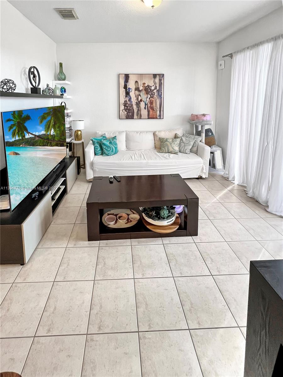 12524 Southwest 126th Avenue Miami, FL 33186 - Photo 10 of 23 a living room with a couch and a stove top oven
