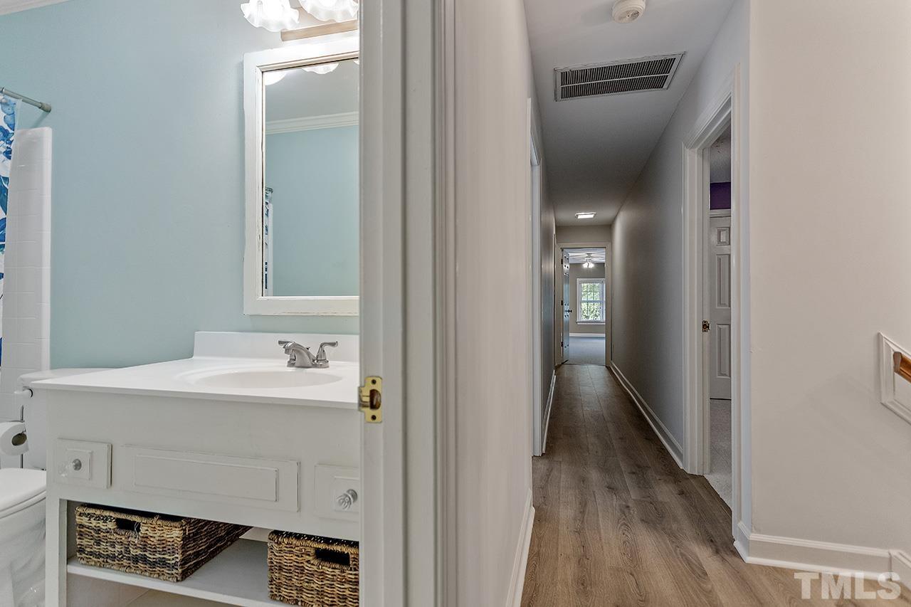 8408 Morgans Way Raleigh, NC 27613 - Photo 24 of 34 a en suite bathroom with a sink a mirror and a vanity