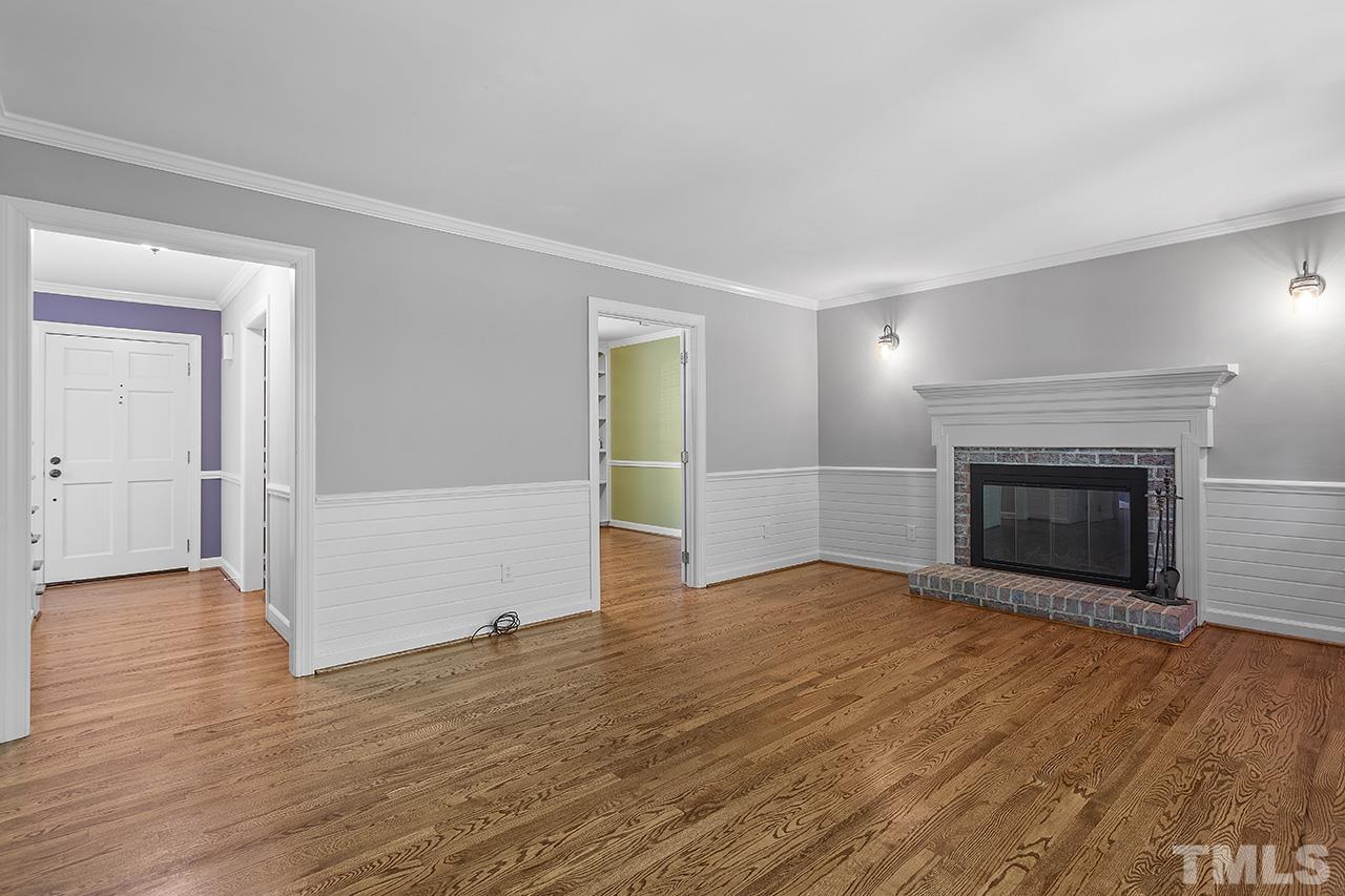 8408 Morgans Way Raleigh, NC 27613 - Photo 8 of 34 an empty room with wooden floor and fireplace